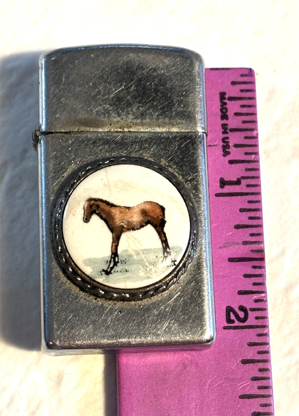 Zippo ligher with raised emblem of horse, slim