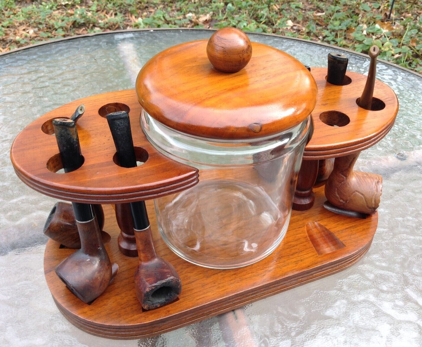 Vtg Duk-It walnut 8 pipe rack 12″ x 6″ oval shape w/glass tobacco jar & 6 pipes